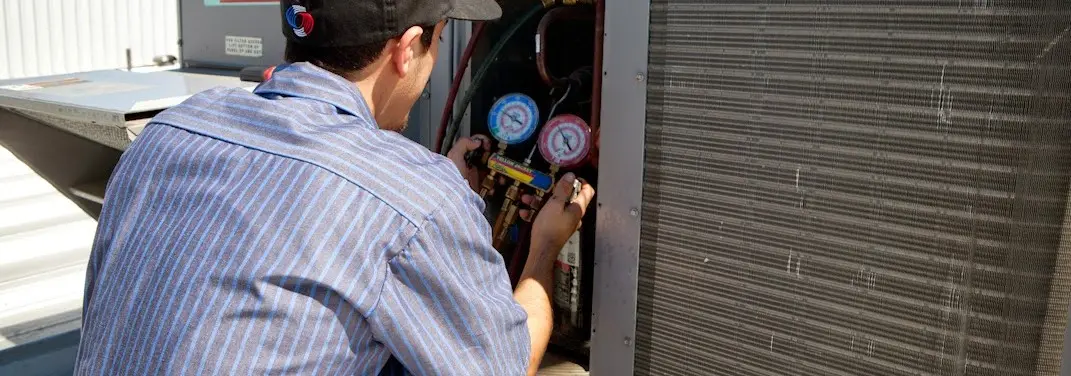 HVAC technician servicing a condenser unit in Sherman